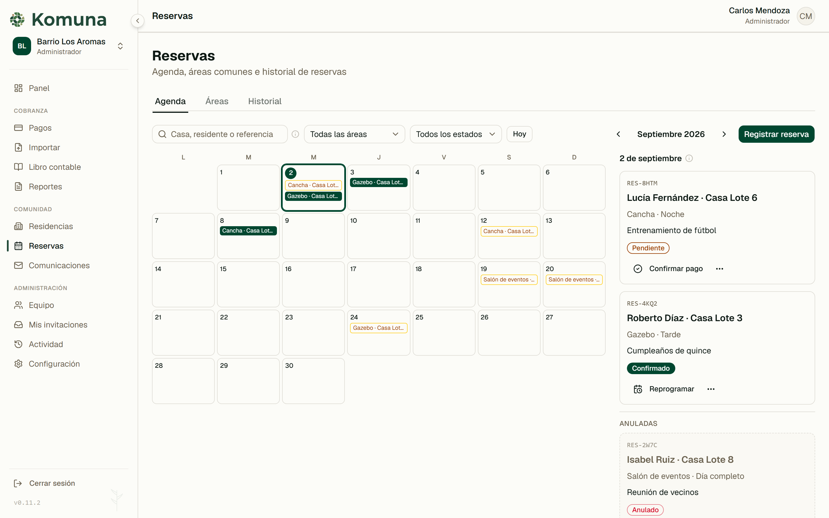 Agenda de reservas de Komuna: el calendario del mes con los días ocupados por área, y el detalle del día con el residente, el estado del cargo y las acciones